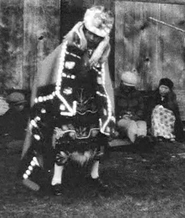 An archival image depicting a Kwakwaka'wakw dancer in regalia.